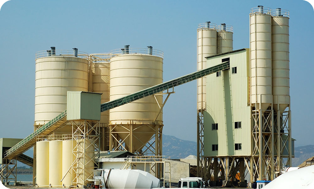 Cement plant silos in the building materials industry, showcasing Mingkai Environmental’s heavy - duty bag cage solutions for abrasive dust.